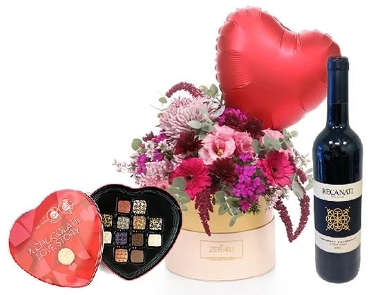 סידור פרחים בגווני ורוד ואדום בקופסא, בשילוב יין אדום ופרליני אהבה