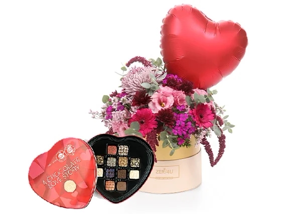 סידור פרחים בקופסה בגווני ורוד בשילוב בלון לב אדום ופרליני שוקולד