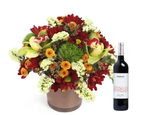 סידור פרחים 'ארגמן' בגווני אדום, כתום, חום וירוק בשילוב בקבוק יין אדום