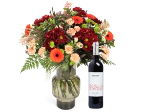 זר פרחים 'כרמן' בגווני אדום, כתום צהוב בשילוב ענפי  קישוט ויין אדום