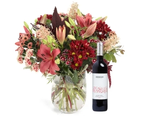 זר פרחים 'אביגיל' בגווני בורדו, חום, שמנת בשילוב ענפים לקישוט ובקבוק יין אדום