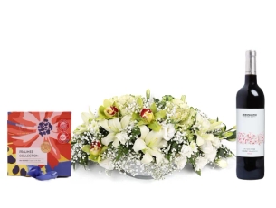 סידור פרחים 'פנינת האביב' על טהרת הלבן בשילוב כלי תואם, בקבוק יין ופרליני שוקולד