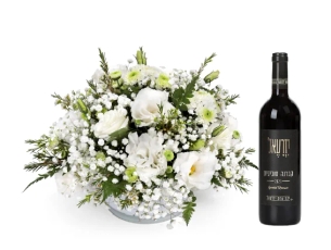 סידור פרחים 'שיה' בגווני לבן בכלי זכוכית לבן, בשילוב בקבוק יין אדום