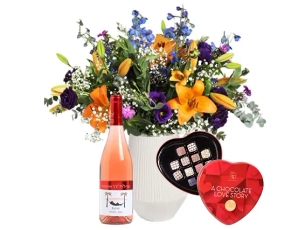 זר פרחים בגווני סגול וכתום, בשילוב בקבוק יין רוזה ופרליני אהבה