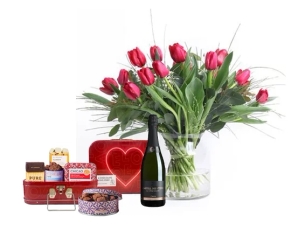 זר טוליפים אדומים בשילוב בקבוק קאווה ומארז שוקולד